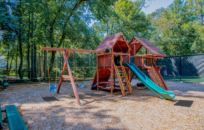 a swing set with a jungle gym in the middle of a park