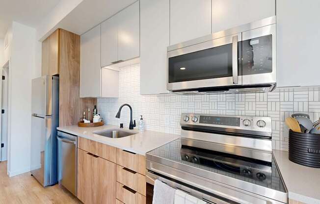 A modern kitchen with a stainless steel oven and microwave above the counter.