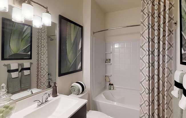 Bathroom with dark cabinets, sink and garden-style bathtub