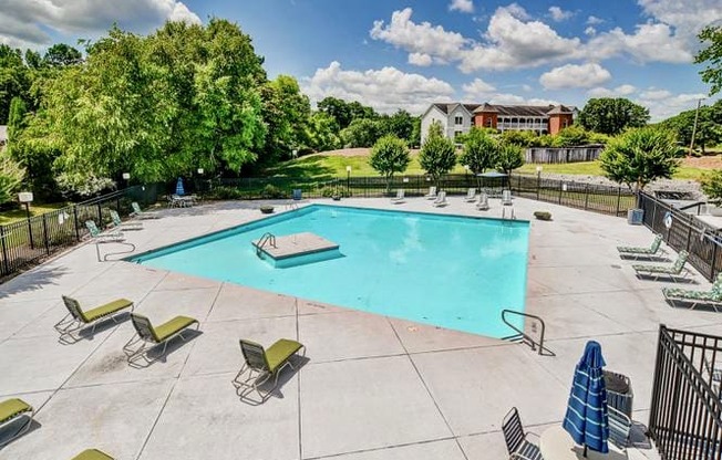 a swimming pool with lounge chairs and a hot tub