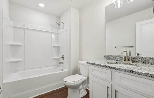 A white bathroom with a toilet, sink, and bathtub.