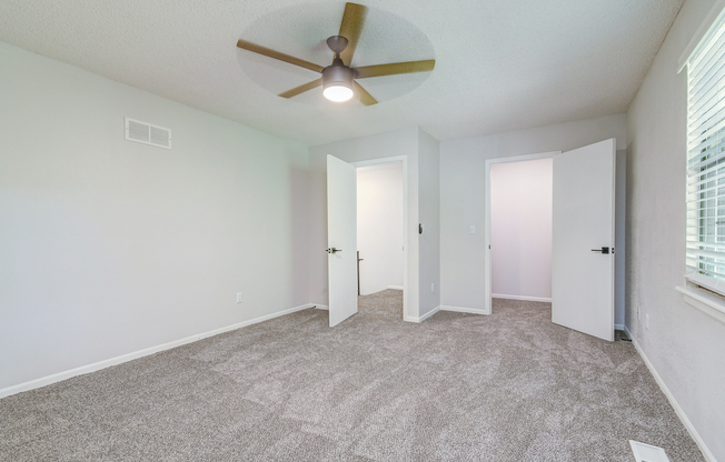 Empty townhome platinum bedroom interior with ceiling fan at The Arbor in Blue Springs, Missouri