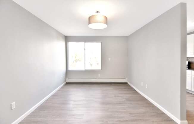 an empty living room with white walls and a window at Springwood Gardens, New Britain, CT