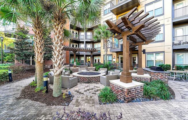 A courtyard with a fire pit and a tree.