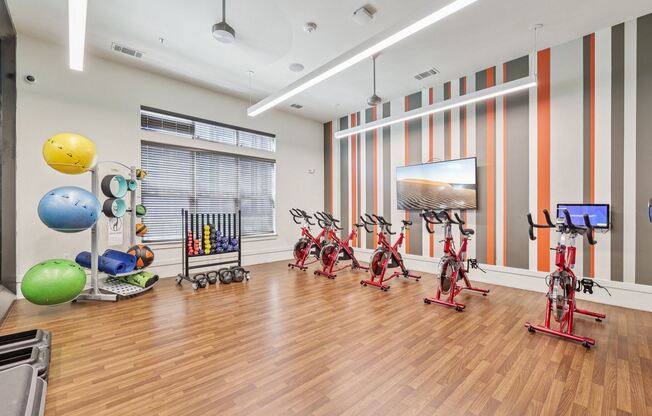 A gym with exercise equipment and a TV.