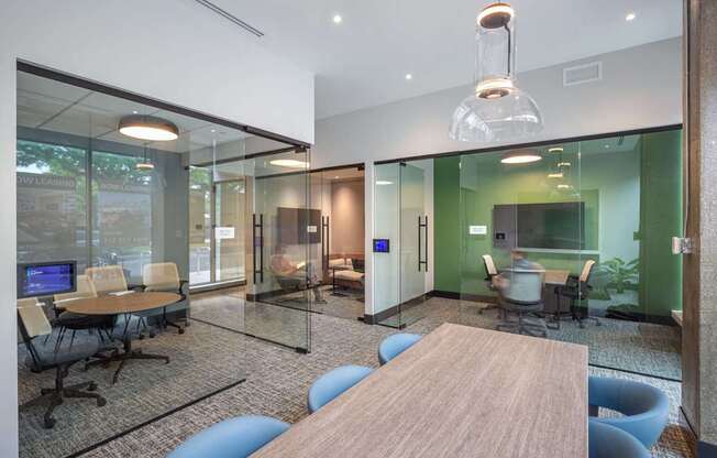 A modern office space with glass walls and a wooden table.