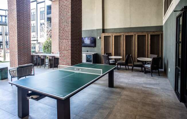 a ping pong table in a room with tables and chairs
