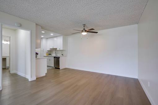 A room with a ceiling fan and wooden flooring.
