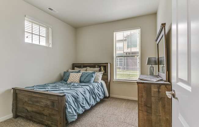 a bedroom with a bed and two windows