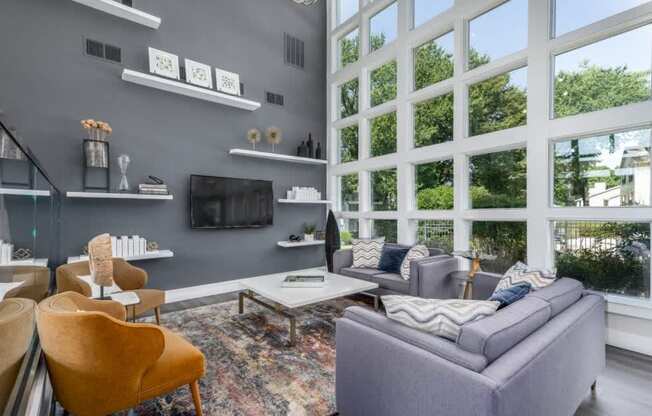 A living room with a grey couch, a yellow chair, and a coffee table.