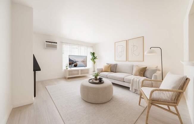 A living room with a white couch, a round coffee table, and a chair.
