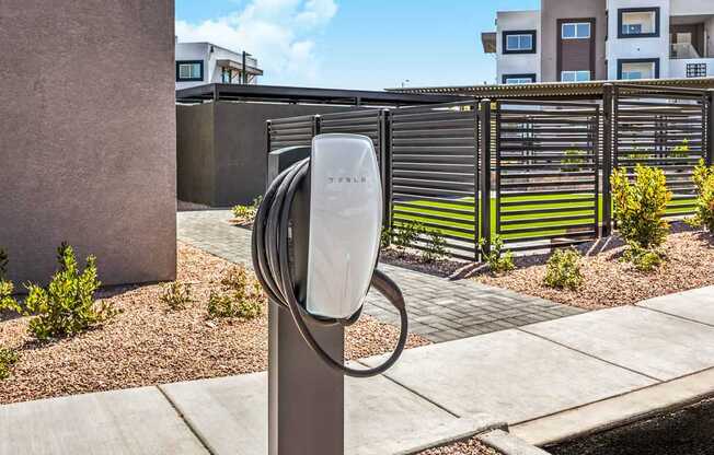 Modern apartment complex featuring electric vehicle charging station with elegant landscaping, showcasing eco-friendly living and convenient amenities at Summit on Boulder Apartments.