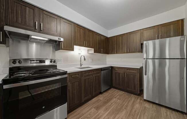 A modern kitchen with dark wood cabinets and stainless steel appliances.