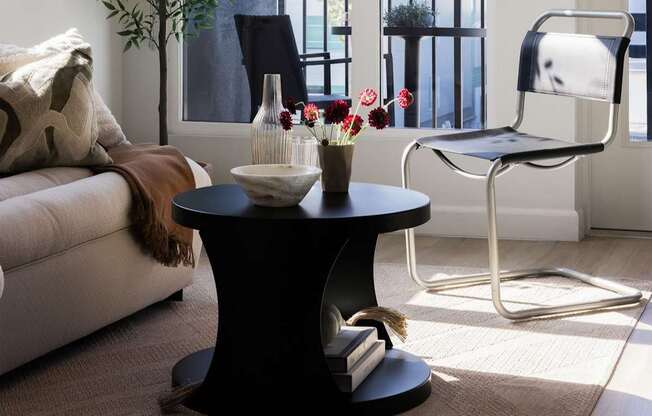 A black coffee table with a vase of flowers on it at Skylar At Sunset Apartments, Los Angeles, CA, 90027