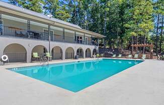 the swimming pool at our apartments with a building and trees