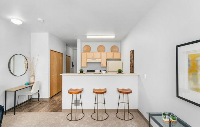 A modern kitchen with a bar area and stools.at Fifth Avenue Place Apartments, Portland, OR