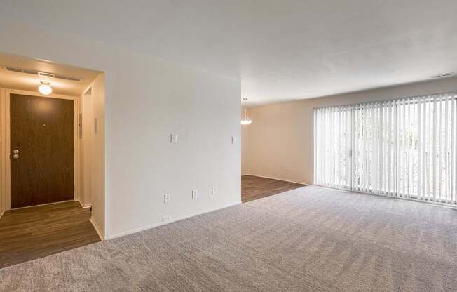 A room with a carpeted floor and a door on the left.