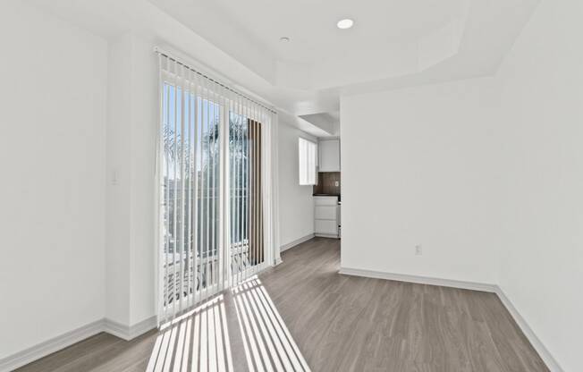 a living room with white walls and a large window