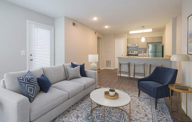 A living room with a grey couch and a blue chair.