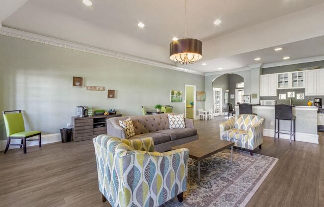 Resident lounge center with chairs, coffee table, and kitchen adjacent