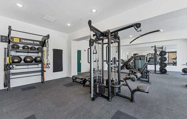 A well-equipped gym with a variety of exercise machines and weights.
