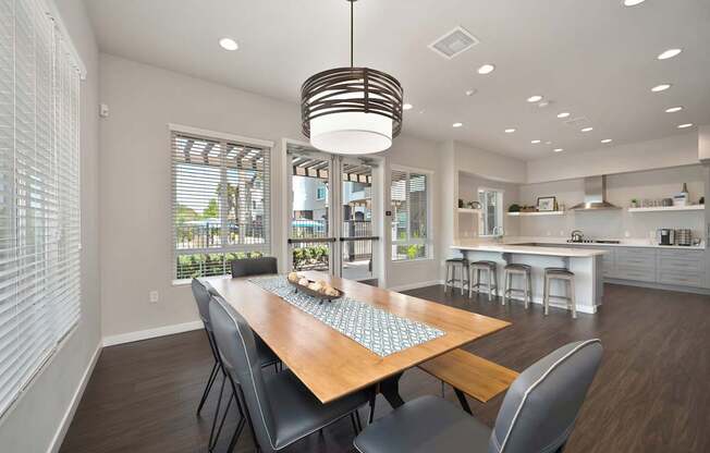 A modern dining room with a wooden table and chairs.