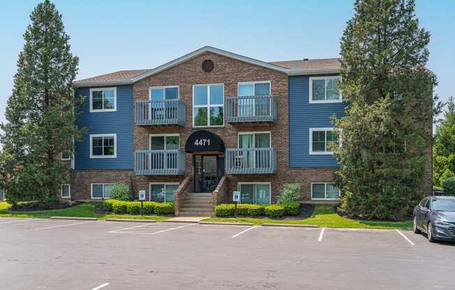 an apartment building with a parking lot in front of it