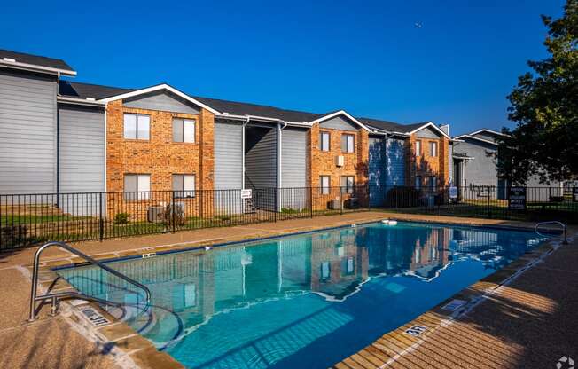 a swimming pool in front of a row of houses at Water Ridge, Irving, Texas