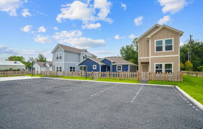 A house with a blue roof is situated in a gravel lot.