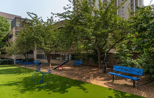 a park with benches and trees in front of a building