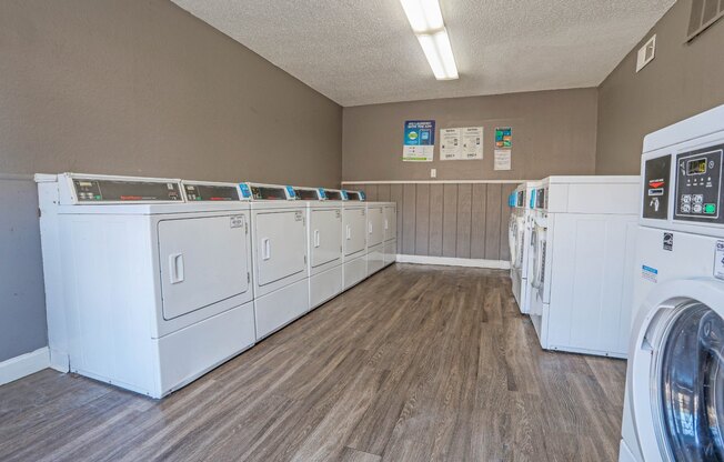 An onsite laundry facility with rows of washers and dryers at Magnolia Apartments in Shreveport, LA