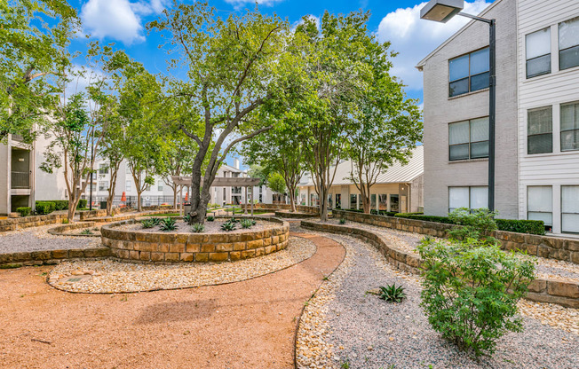 a courtyard between two buildings with trees and plants