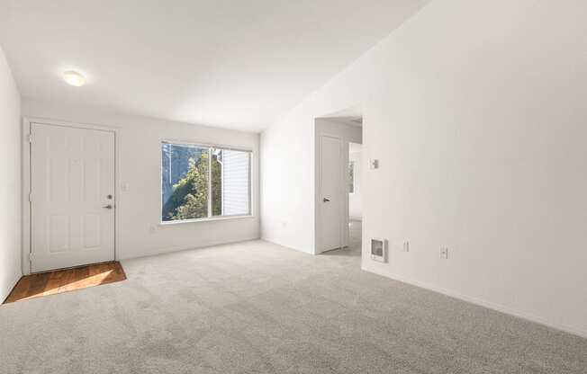 Living room with white walls and carpeted floor with a window and two doors at Clackamas Trails Apartments, Oregon, 97222