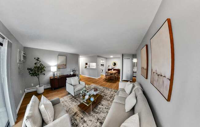 a living room with white furniture and a rug