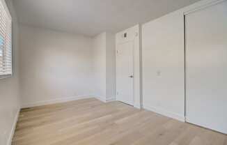 A room with a white door and a white wall.