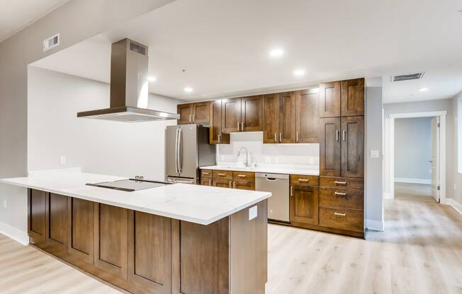 a large kitchen with wooden cabinets and a white counter top