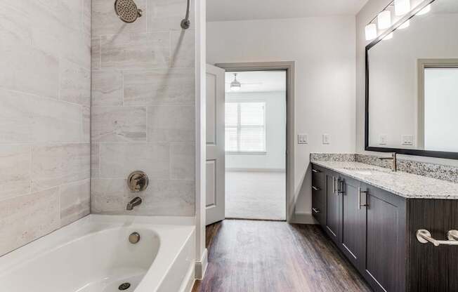 A bathroom with a white tub and a walk-in shower.