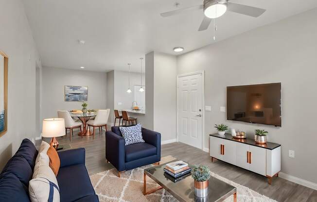A living room with a blue couch and a television on a cabinet.