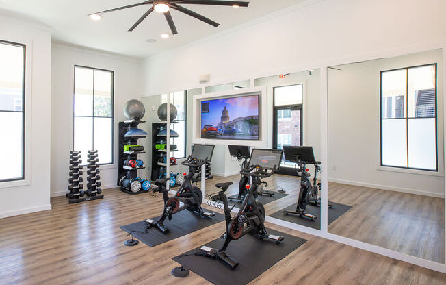 a home gym with weights and a tv on the wall