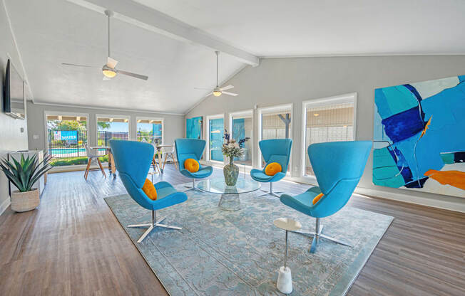 a living room with blue chairs and a glass table