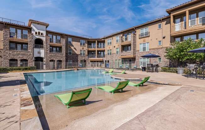 our apartments have a large swimming pool with green chairs