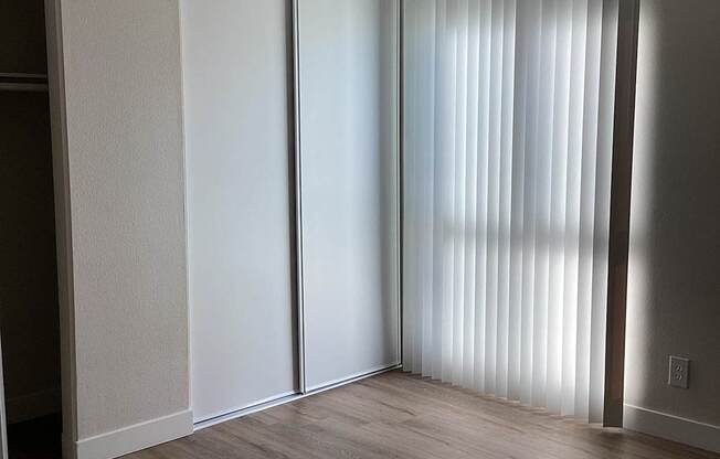 A room with a sliding door and a wooden floor.