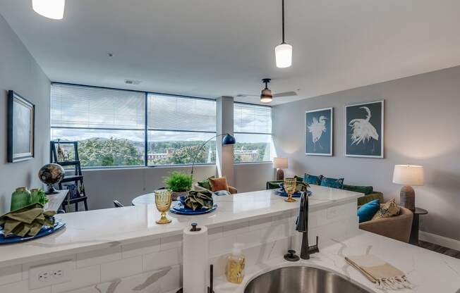 an open kitchen and living room with a large window and a sink