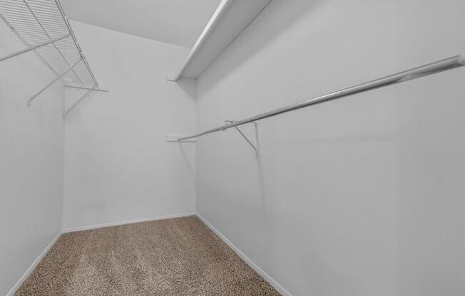 an empty room with white walls and a closet with a metal rail on the wall at Edge At Farmington Hills - Farmington Hills, MI, Michigan