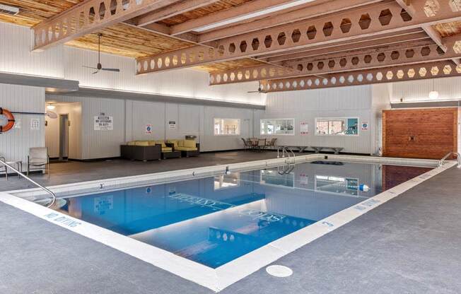 a large indoor swimming pool with a wooden ceiling