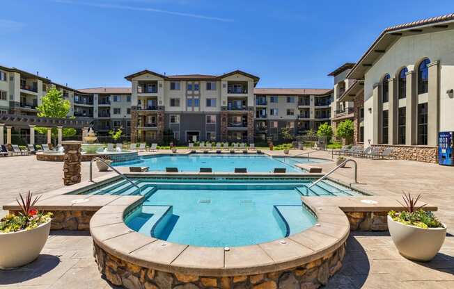 1-Bedroom Apartments in Broomfield, CO - Terracina - Resort-Style Swimming Pool with Hot Tub, Fountain, and Lounge Chairs.