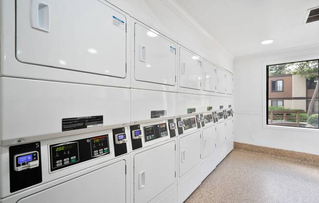 a white utility room with white appliances and a window