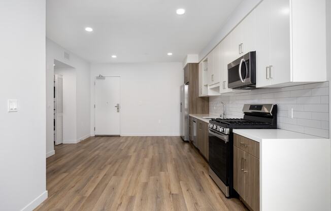 a kitchen with white cabinets and a stove and a microwave