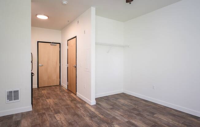a bedroom with white walls and wood floors