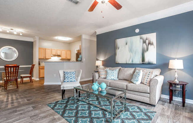 A living room with a couch, chairs, and a rug.